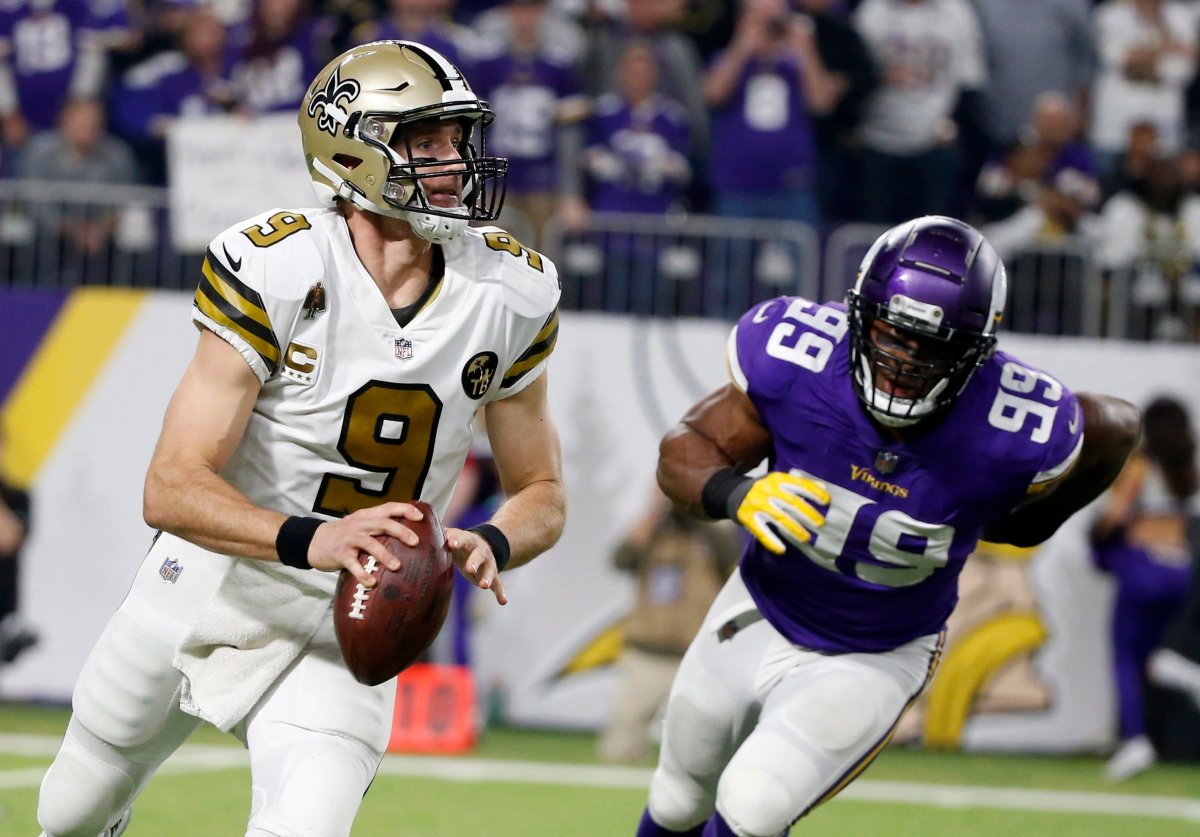 New Orleans Saints quarterback Drew Brees runs from Minnesota Vikings defensive end Danielle Hunter, right, during the second half of an NFL football game, Sunday, Oct. 28, 2018, in Minneapolis.
