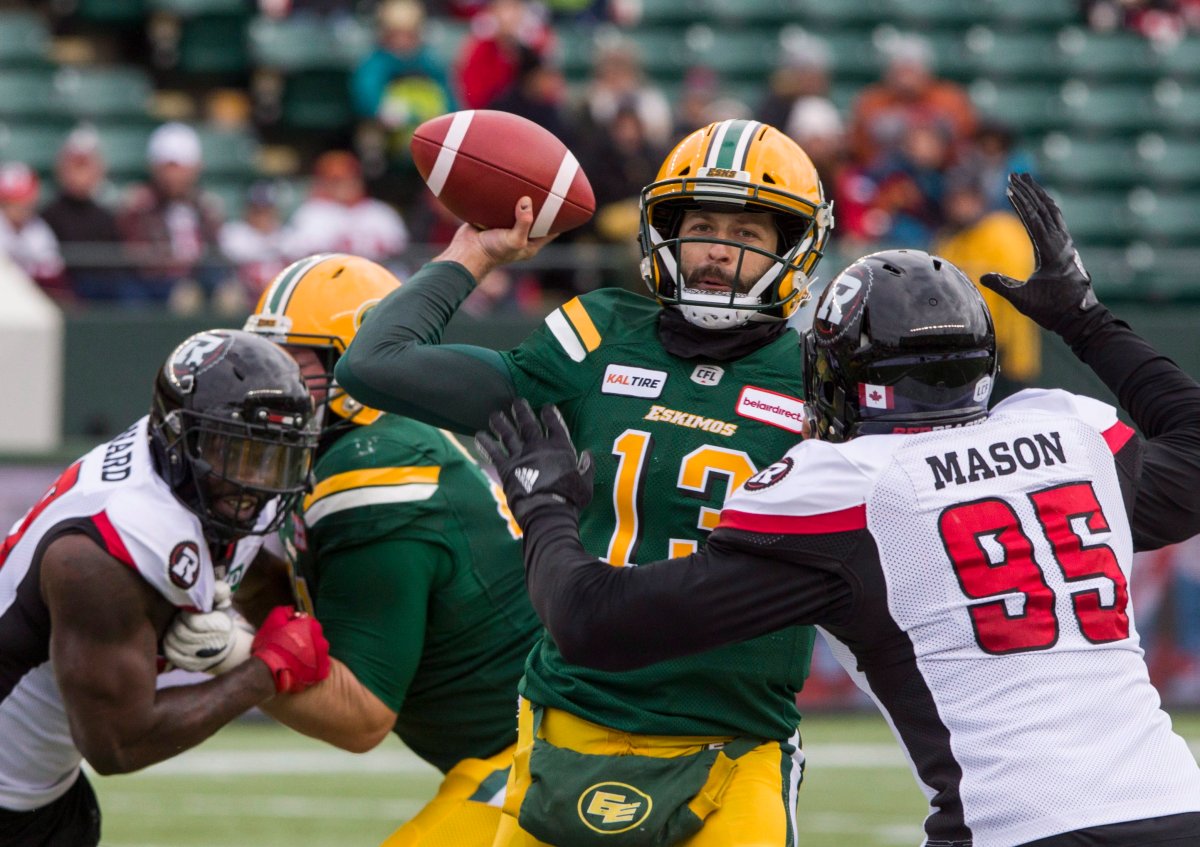 Edmonton Eskimos quarterback Mike Reilly gets the ball out under pressure from Ottawa Redblacks' Danny Mason (95) during first half CFL action in Edmonton on Saturday, Oct. 13, 2018.