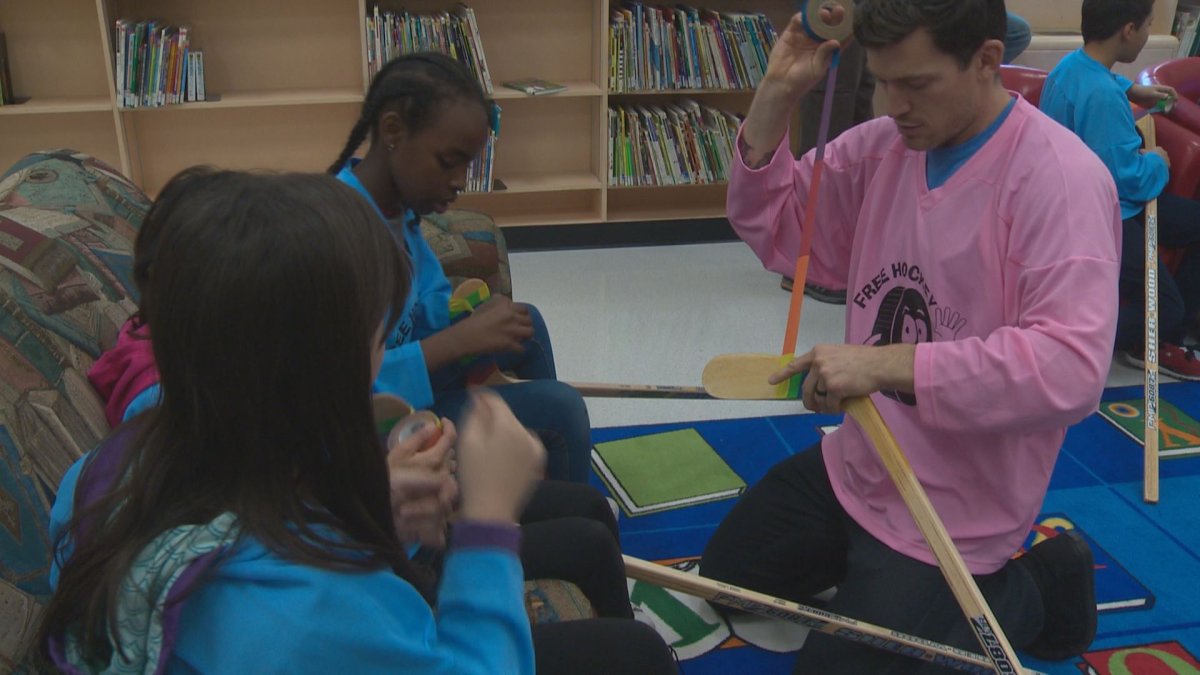 Former Oilers captain, Andrew Ference, uses Pride Tape to teach students how to tape their hockey sticks. 