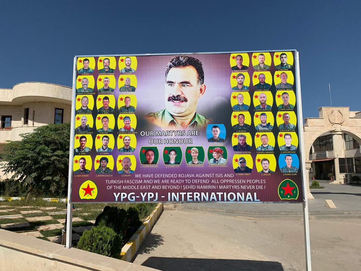 A billboard in Kurdish-controlled northeast Syria shows PKK leader Abdullah Ocalan and photos of foreign volunteers killed fighting ISIS with Kurdish forces.