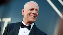 Bruce Willis appears in a tuxedo on the red carpet.