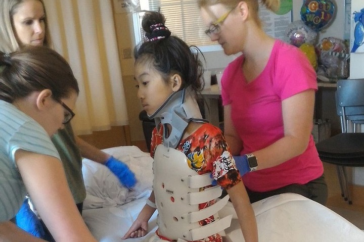 Hailey Cheng wears a stiff body brace in therapy to protect her spine at the Glenrose Rehabilitation Centre in Edmonton.