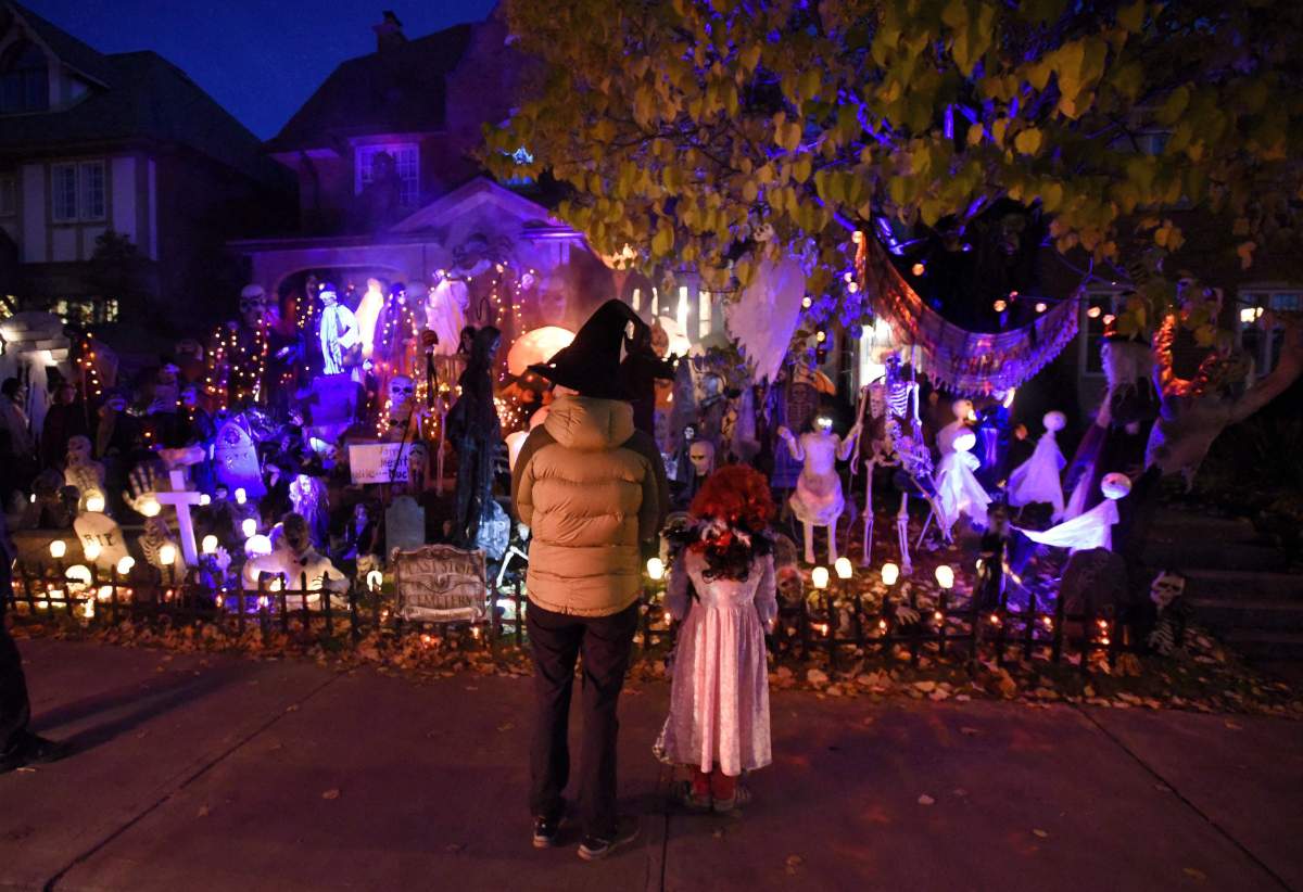 People go trick-or-treating at a decorated home in the Glebe neighbourhood in Ottawa on Halloween on October 31, 2016.