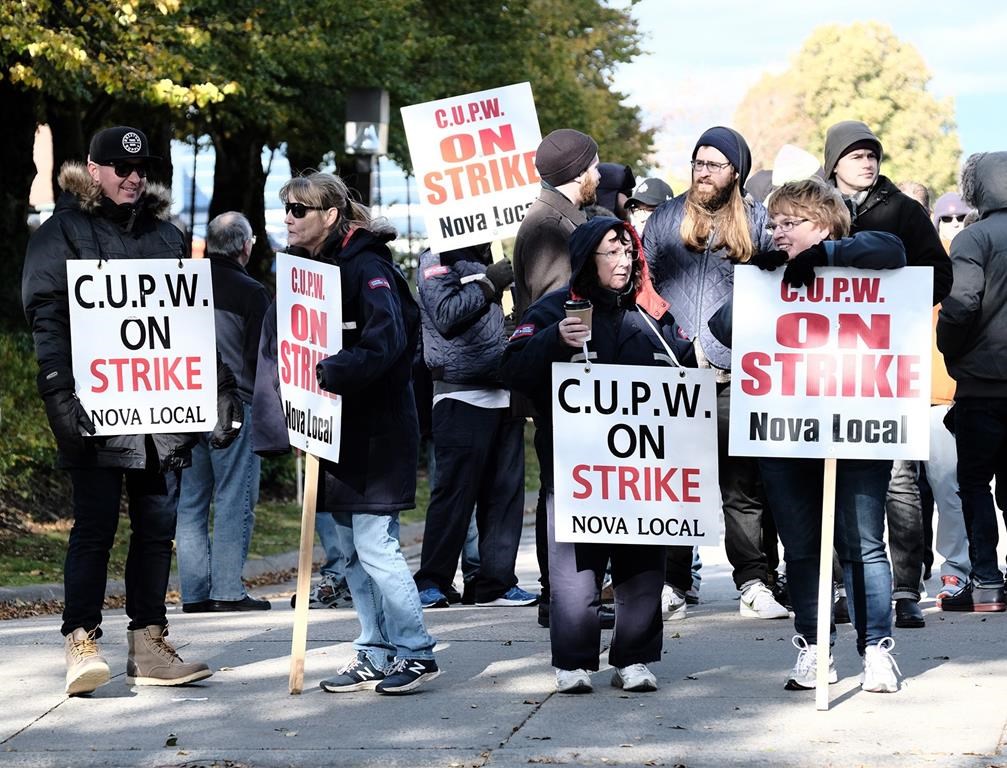 Canadian Union of Postal Workers (CUPW) members stand on picket line along Almon St., in front of the Canada Post regional sorting headquarters in Halifax on Monday, Oct.22, 2018 after a call for a series of rotating 24-hour strikes. THE CANADIAN PRESS/Ted Pritchard.
