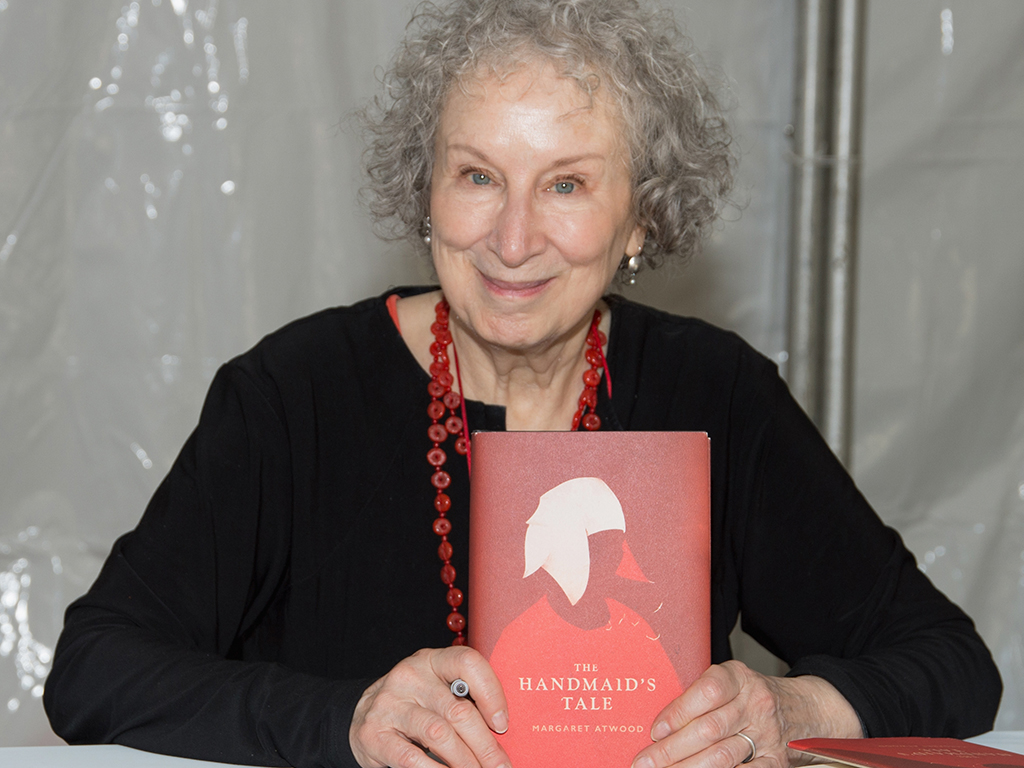 Author Margaret Atwood holding a copy of her novel The Handmaid's Tale. 