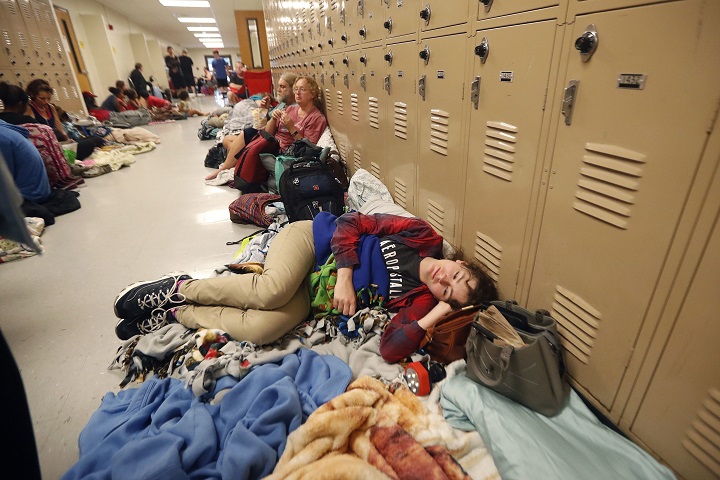 Emily Hindle lies on the floor at an evacuation shelter set up at Rutherford High School, in advance of Hurricane Michael, which is expected to make landfall in Panama City Beach, Fla., Wednesday, Oct. 10, 2018.