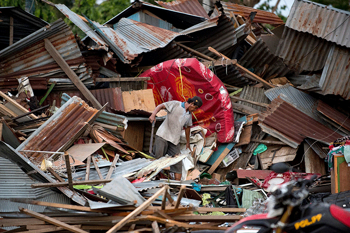 A man looks through the debris of his destroyed house in Palu in Central Sulawesi on September 29, 2018.