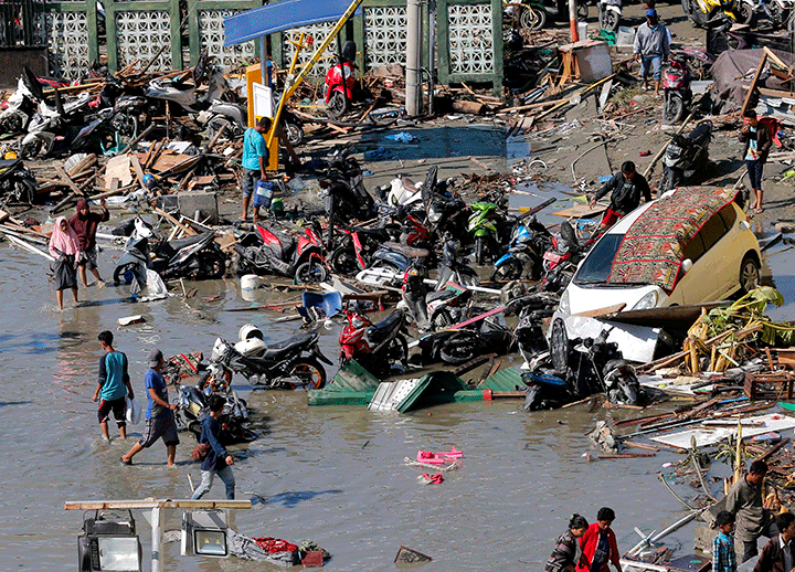 People survey damage outside the shopping mall following earthquakes and tsunami in Palu, Central Sulawesi, Indonesia, Sept. 30, 2018.