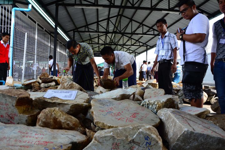 In this photo taken on Oct 13, 2014, merchants inspect jade stones displayed at the annual Gems Emporium in the capital Naypyitaw, Myanmar.