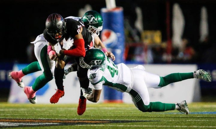 Saskatchewan Roughriders' Derrick Moncrief and Cameron Judge bring down Calgary Stampeders' Markeith Ambles during CFL action on Oct. 20, 2018.