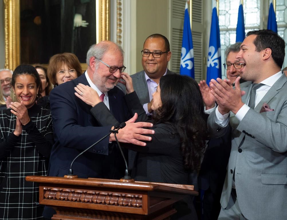Interim Quebec Liberal opposition leader Pierre Arcand, centre left, is congratulated by Liberal caucus president Filomena Rotiroti, centre right, while caucus members applaud, on Friday, Oct. 5, 2018 at the legislature in Quebec City.