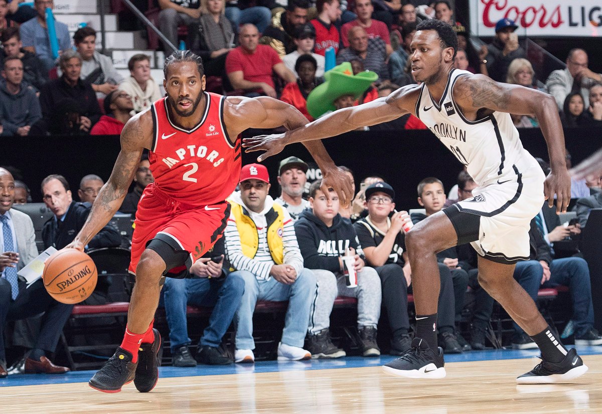 Toronto Raptors' Kawhi Leonard (2) drives to the basket as Brooklyn Nets' Treveon Graham during first half NBA pre-season basketball action in Montreal, Wednesday, Oct. 10, 2018.