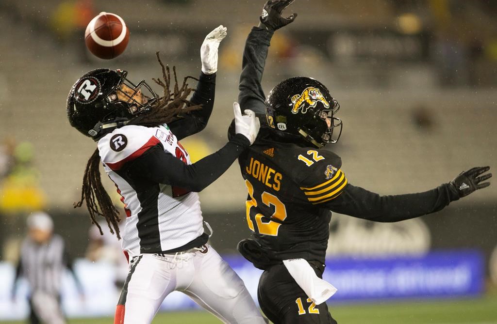 Hamilton Tiger-Cats wide receiver Mike Jones (12) can not get his hands on the ball while defended by Ottawa Redblacks Sherrod Baltimore during second half CFL Football game action in Hamilton, Ont. on Saturday, October 27, 2018. THE CANADIAN PRESS/Peter Power