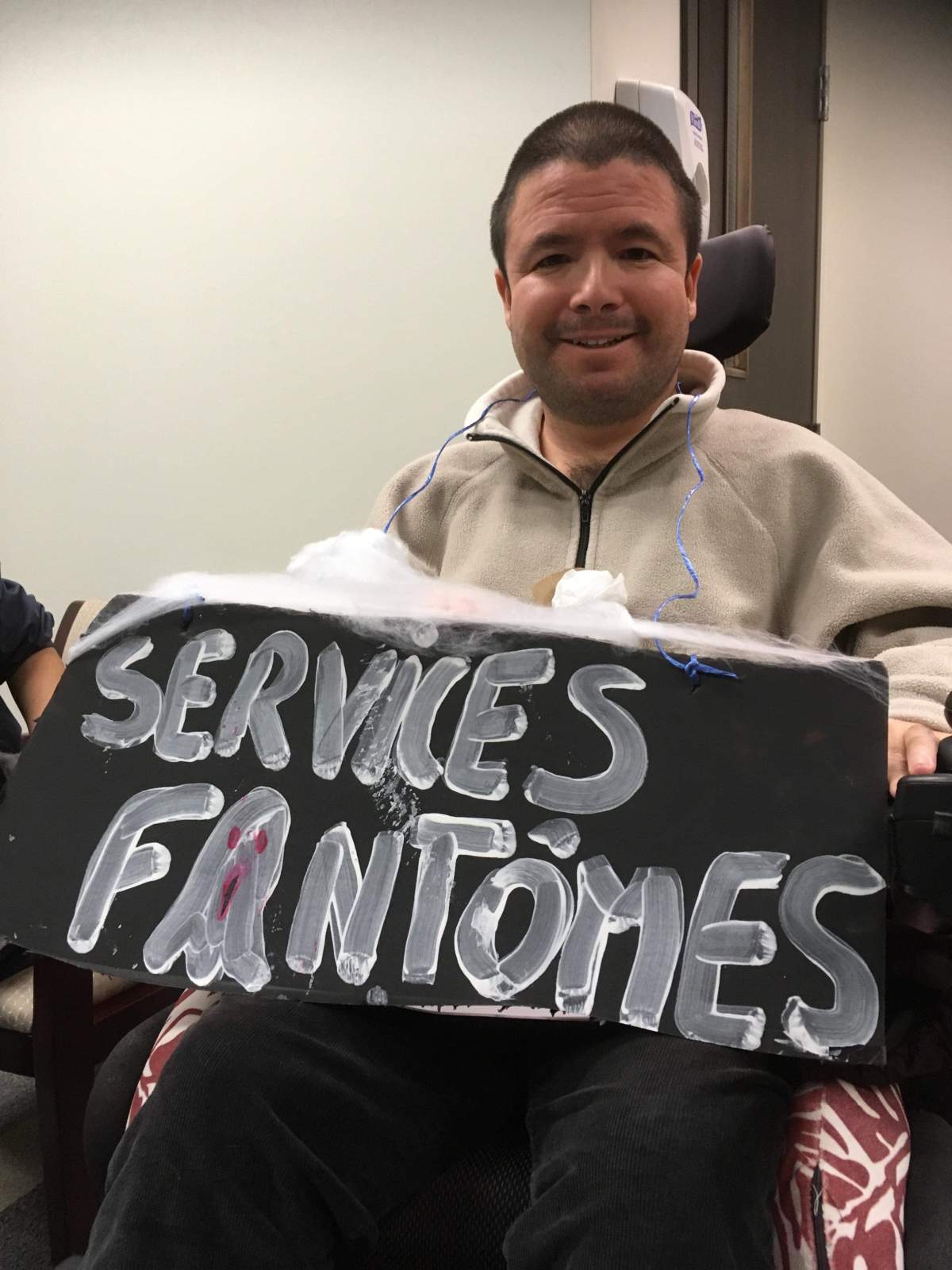 Martin Dion, the member of Mouvement PHAS, holds up a sign at the occupation.