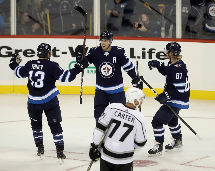 Winnipeg Jets' Brandon Tanev (13), Mark Scheifele (55) and Kyle Connor (81) celebrate after Scheifele scored as Los Angeles Kings' Jeff Carter (77) looks on during first-period NHL hockey action in Winnipeg, Tuesday, Oct. 9, 2018.