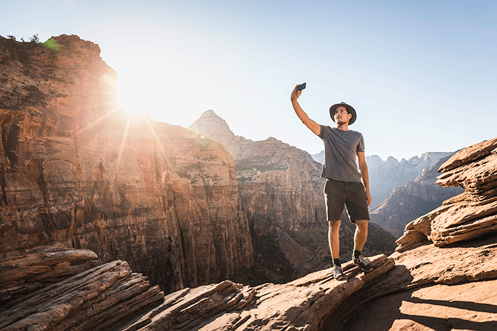 A man takes a selfie with a smartphone at Zion National Park in Utah. 