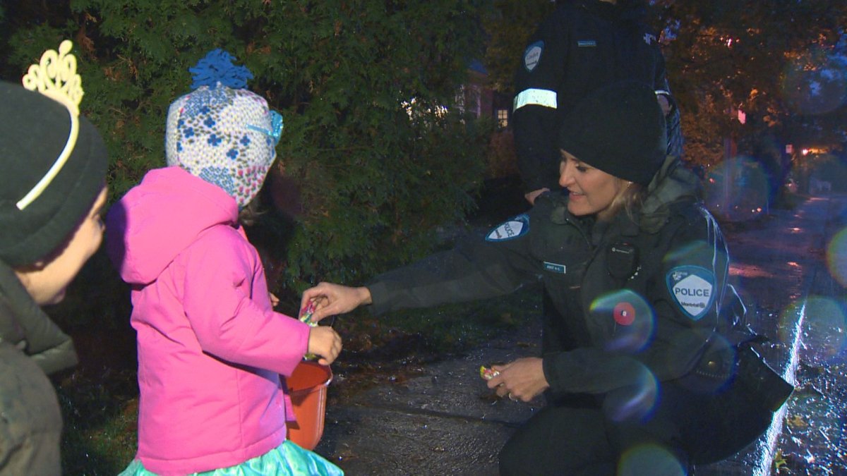 Police officers handing out candy while patrolling on Halloween in Montreal-West. Wednesday, October 31, 2018.