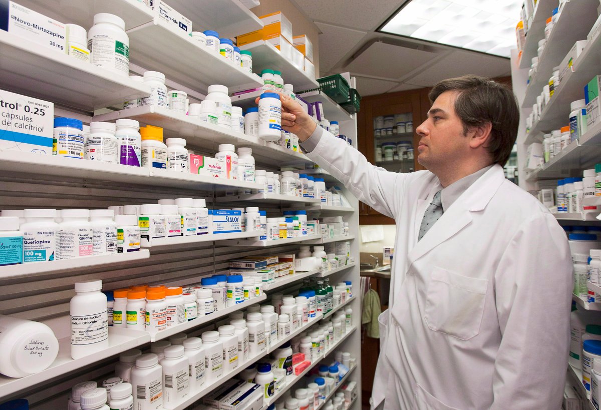 Pharmacist Denis Boissinot checks a bottle on a shelf at his pharmacy on March 8, 2012, in Quebec City.