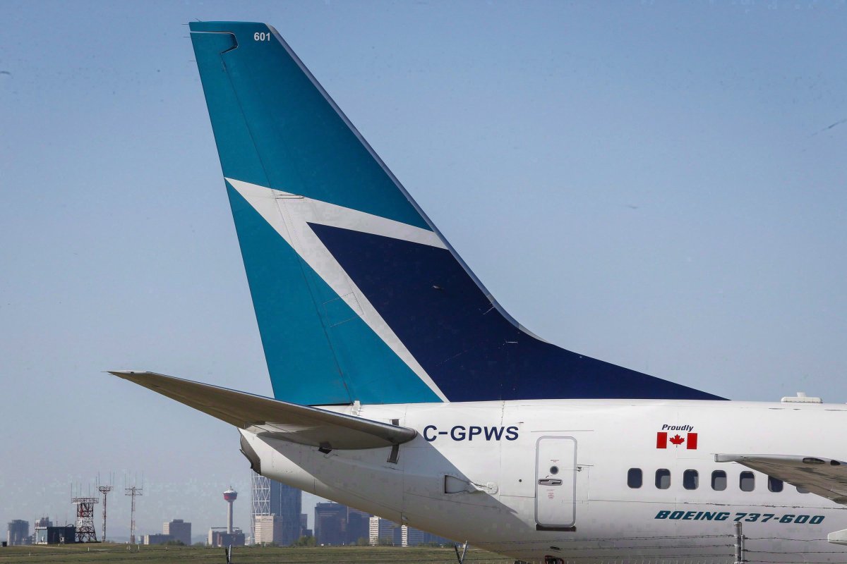 The tail of a WestJet plane is seen dwarfing the Calgary skyline before the airline's annual meeting in Calgary on May 3, 2016. 