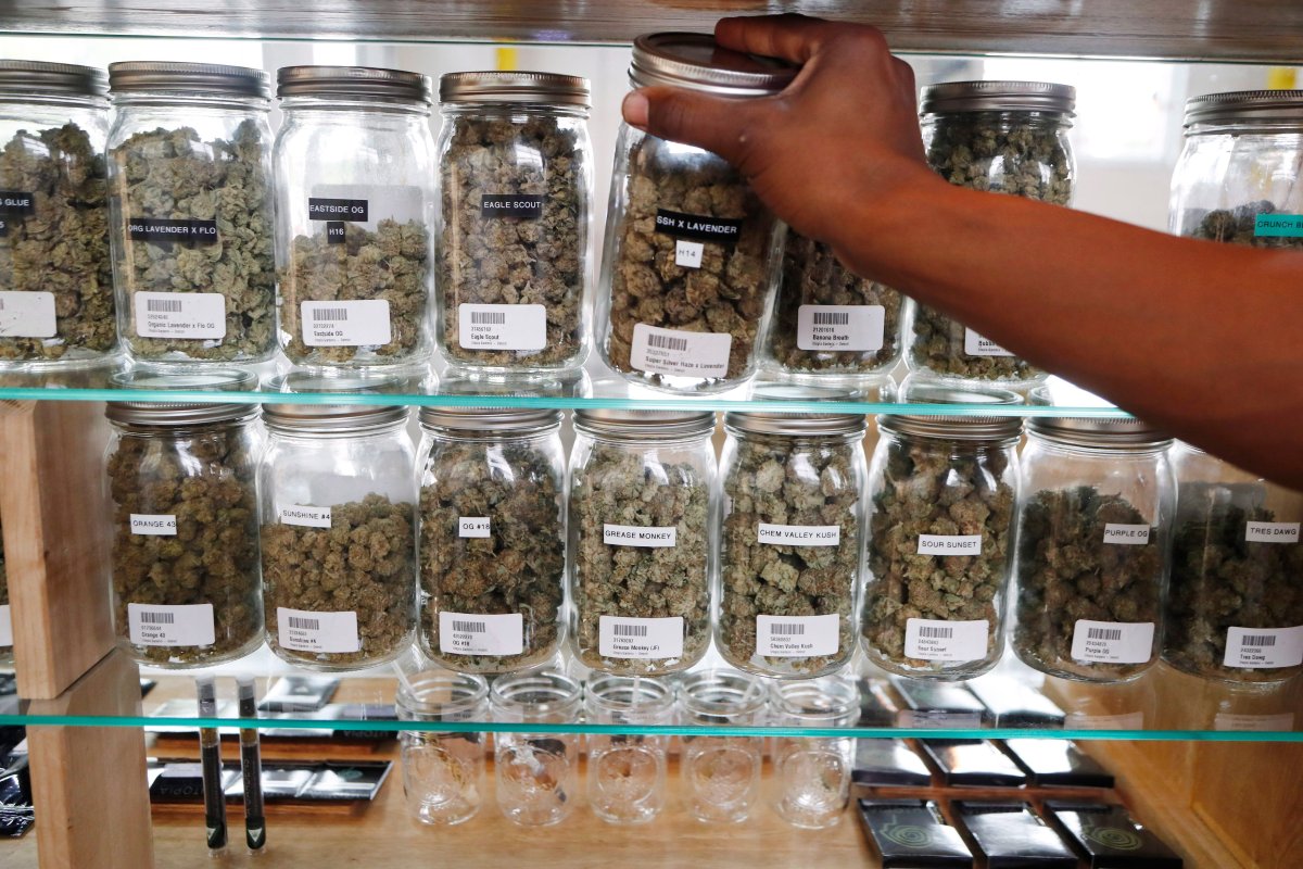 In this Tuesday, Oct. 2, 2018, photo, a clerk reaches for a container of marijuana buds for a customer at Utopia Gardens, a medical marijuana dispensary, in Detroit. 