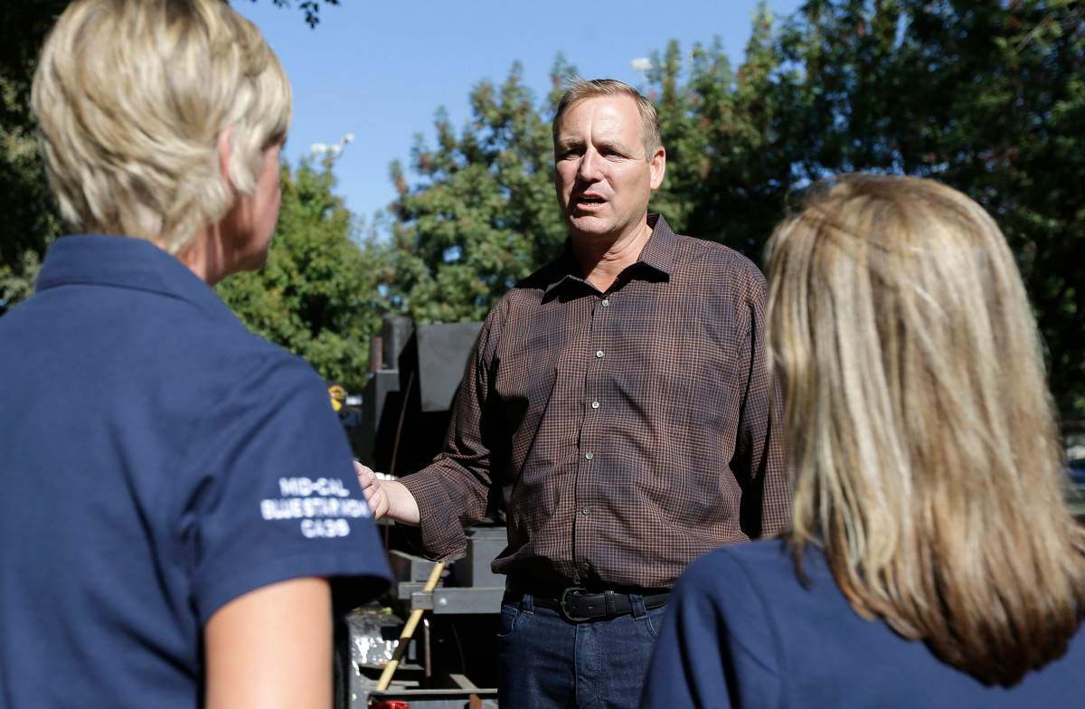 In this photo taken Thursday, Oct. 25, 2018, Rep. Jeff Denham talks with Blue Star Mothers Lori Prins, left, and Stacy Fournet, right, during his appearance at the 3rd Annual Veterans Stand Down in Modesto, Calif.