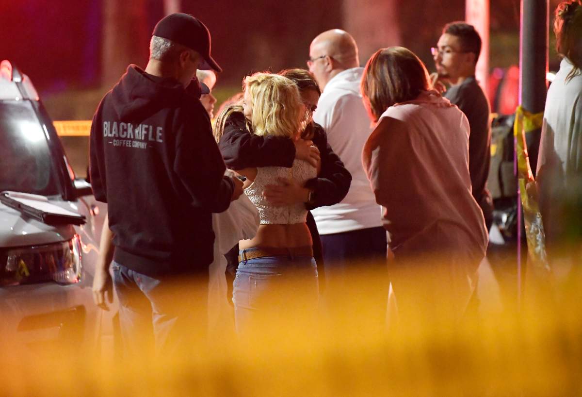People comfort each other as they stand near the scene Thursday, Nov. 8, 2018, in Thousand Oaks, Calif. where a gunman opened fire Wednesday inside a country dance bar crowded with hundreds of people on “college night,” wounding 11 people including a deputy who rushed to the scene. Ventura County sheriff’s spokesman says gunman is dead inside the bar. (AP Photo/Mark J. Terrill)