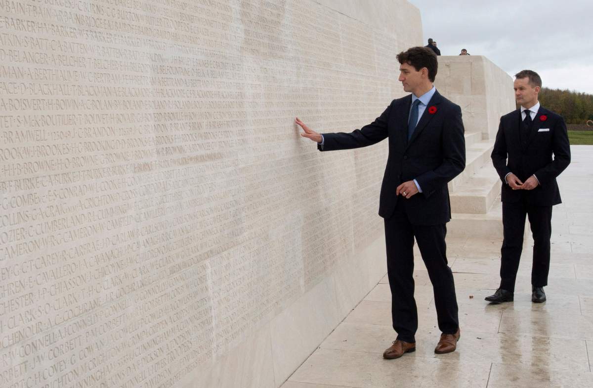 Minister of Veterans Affairs Seamus O’Regan looks on as Canadian Prime Minister Justin Trudeau touches the names of fallen soldiers engraved in the Canadian National Vimy Memorial, Saturday November 10, 2018 at Vimy Ridge, France.