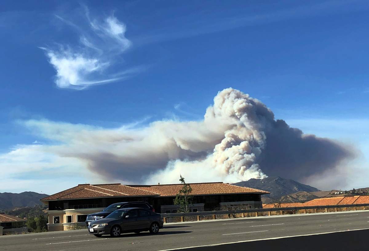 A large wildfire plume from a recent flareup near Lake Sherwood, Calif., is visible from Highway 101 north of Los Angeles, Tuesday, Nov. 13, 2018.