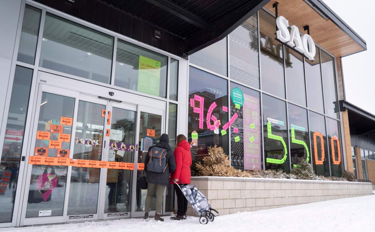 Two patrons read the notice on the door of a closed liquor store in Montreal on Friday, November 16, 2018.  (Paul Chiasson/The Canadian Press)
