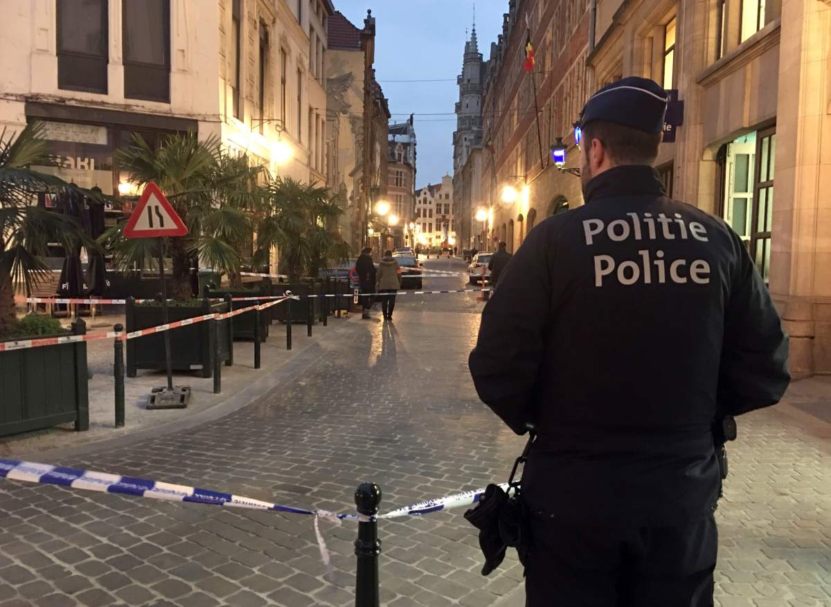 A police officer stands behind a police tape during investigations at a stabbing scene in the center of Brussels, Tuesday, Nov. 20, 2018. 