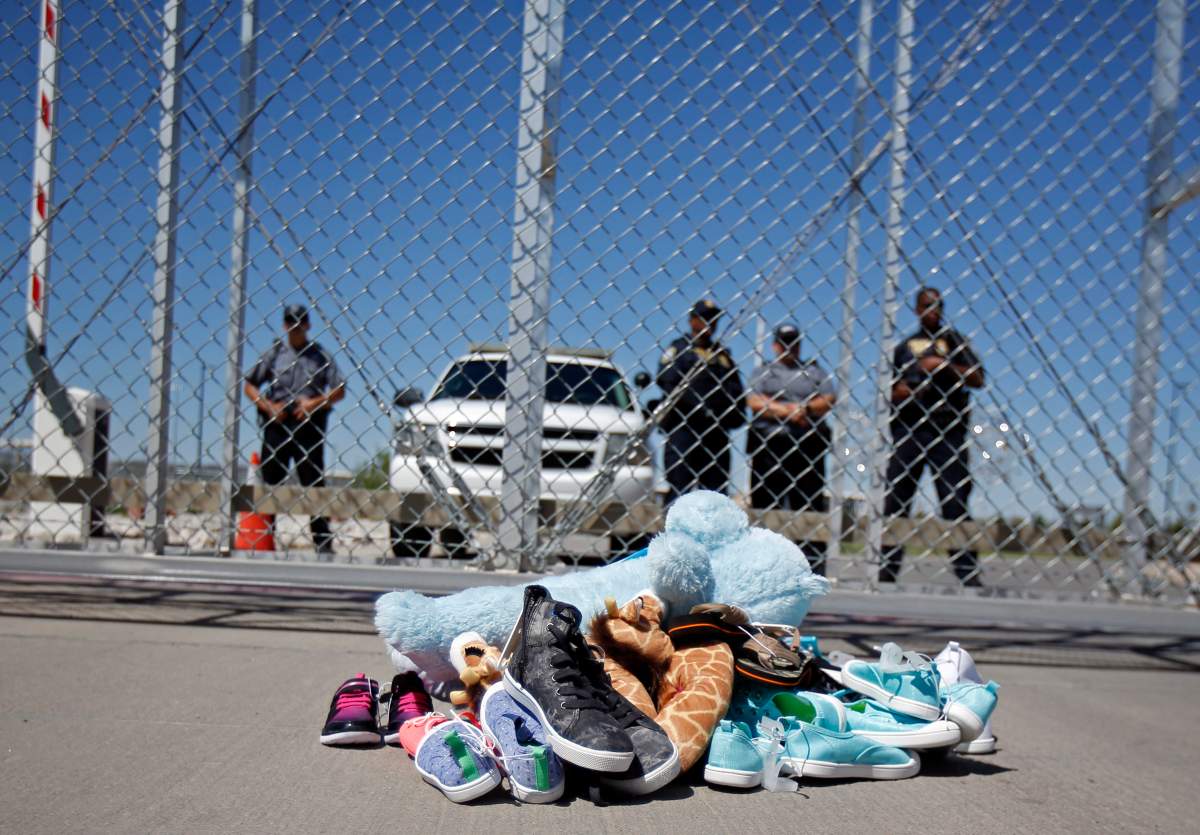 In this June 21, 2018, photo shoes and a teddy bear, brought by a group of U.S. mayors, are piled up outside a holding facility for immigrant children in Tornillo, Texas, near the Mexican border.
