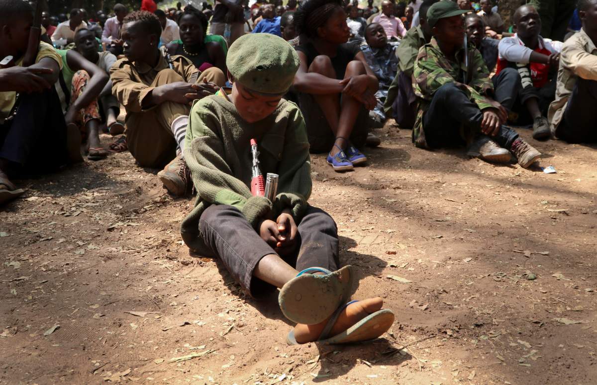 A young child soldier sits on the ground at a release ceremony, where he and others laid down their weapons and traded in their uniforms to return to "normal life", in Yambio, South Sudan, Feb. 7, 2018.


