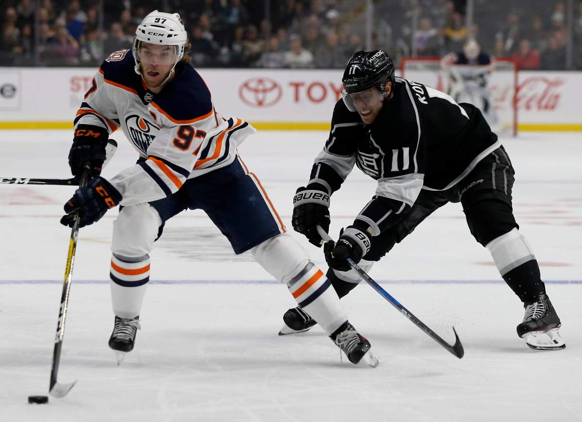 Edmonton Oilers center Connor McDavid, left, controls the puck under pressure by Los Angeles Kings center Anze Kopitar (11), of Slovenia, during the third period of an NHL hockey game in Los Angeles, Sunday, Nov. 25, 2018. The Kings won 5-2. (AP Photo/Alex Gallardo).