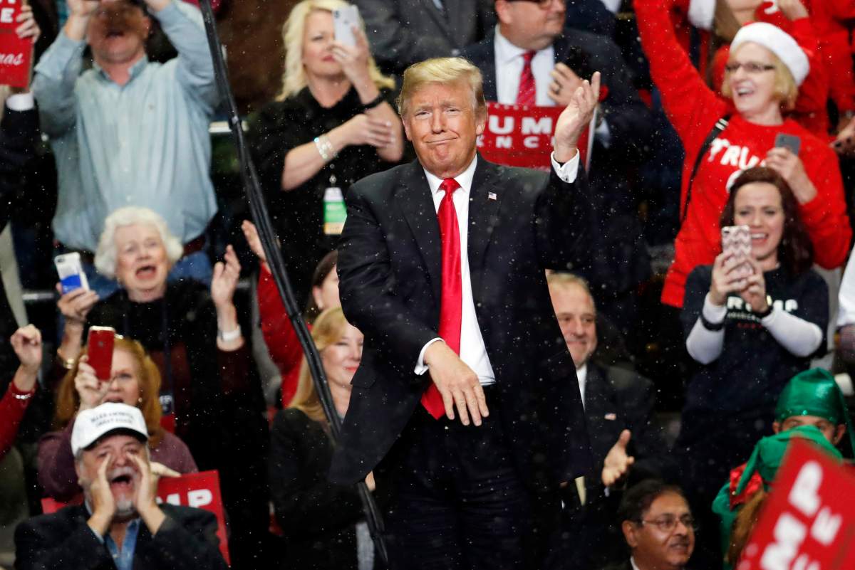 President Donald Trump gestures as he acknowledges the fake snow that fell as he entered the Mississippi Coast Coliseum for a rally Monday, Nov. 26, 2018, in Biloxi, Miss.