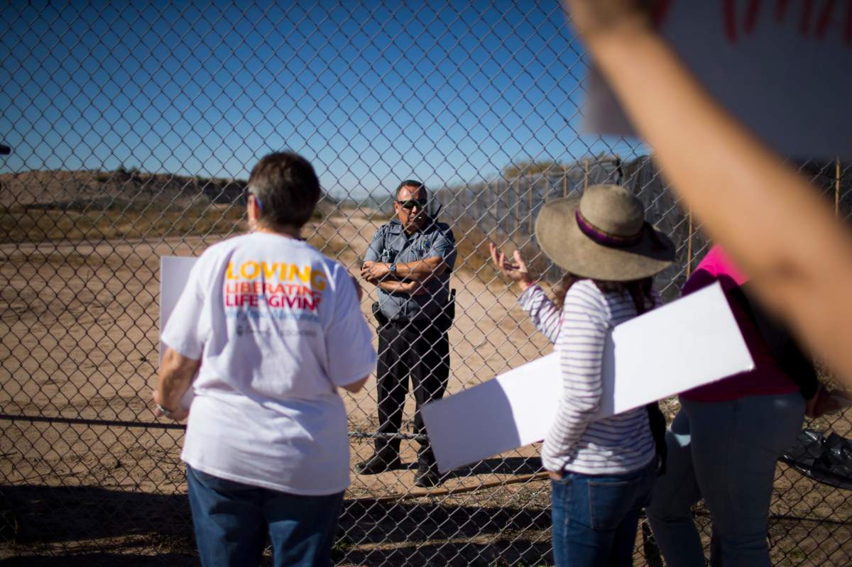 In this Nov. 15, 2018 photo provided by Ivan Pierre Aguirre, protesters talk to a guard inside the Tornillo detention camp holding more than 2,300 migrant teens in Tornillo, Texas.