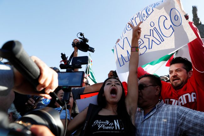 A pro-migration activist shouts slogans in front of demonstrators during a protest against migrants who are part of a caravan traveling en route to the United States, in Tijuana, Mexico November 18, 2018.