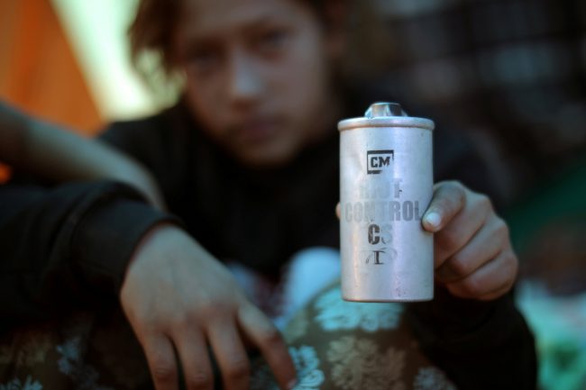 Jamie Mejia Meza, 12, from Honduras holds a tear gas canister she picked up as she sits in a temporary shelter in Tijuana, Mexico, Nov. 26, 2018.