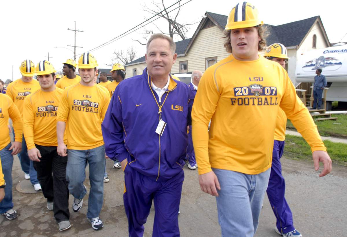 Peter Dyakowski and Louisiana State football coach Les Miles tour the Musicians’ Village where Habitat for Humanity is building houses for New Orleans musicians affected by Hurricane Katrina, in this Dec. 29, 2006 file photo. (AP Photo/Cheryl Gerber)