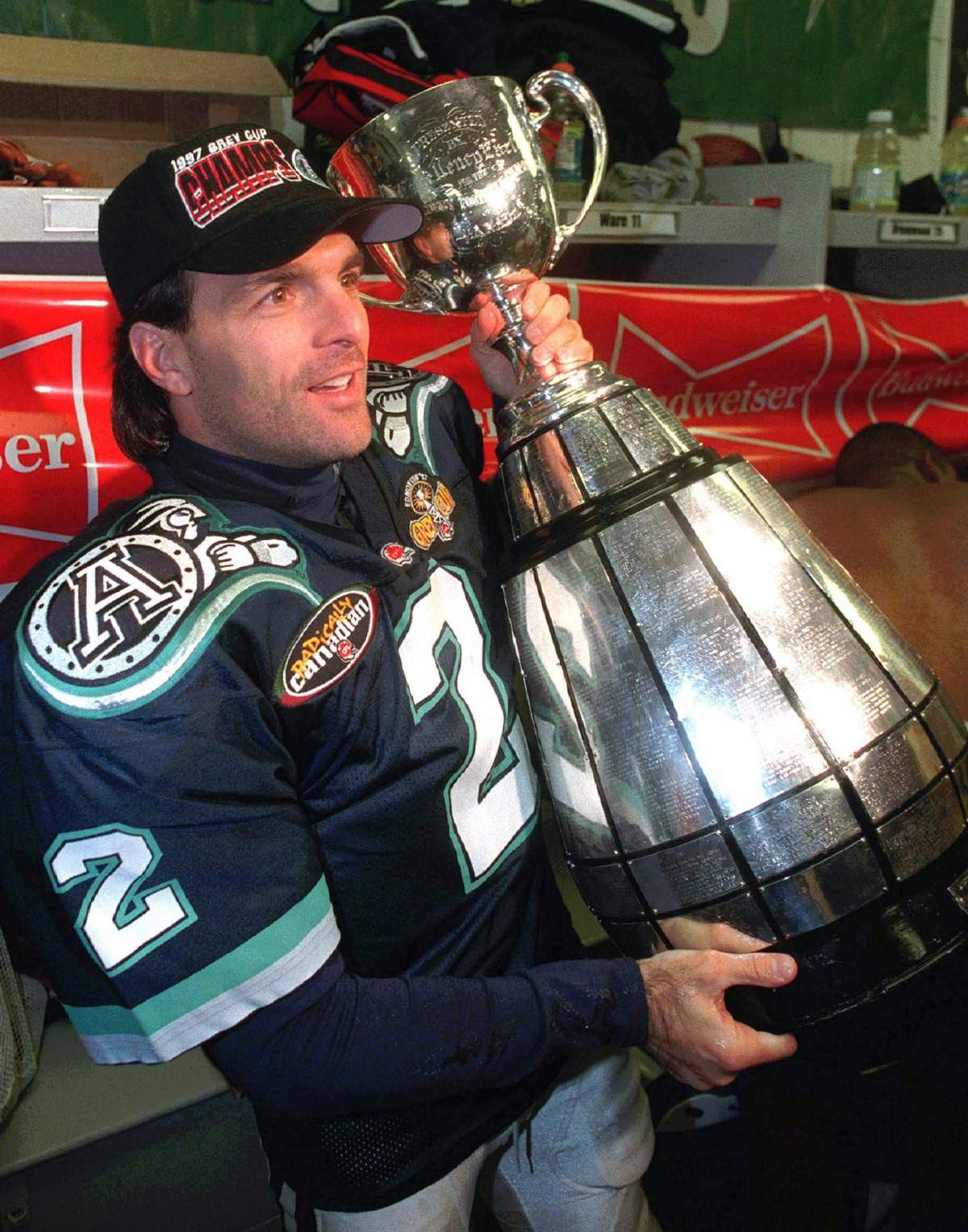 Toronto Argonauts quarterback and game MVP Doug Flutie poses with the Grey Cup in the team dressing room after defeating Saskatchewan Roughriders in November 1997.