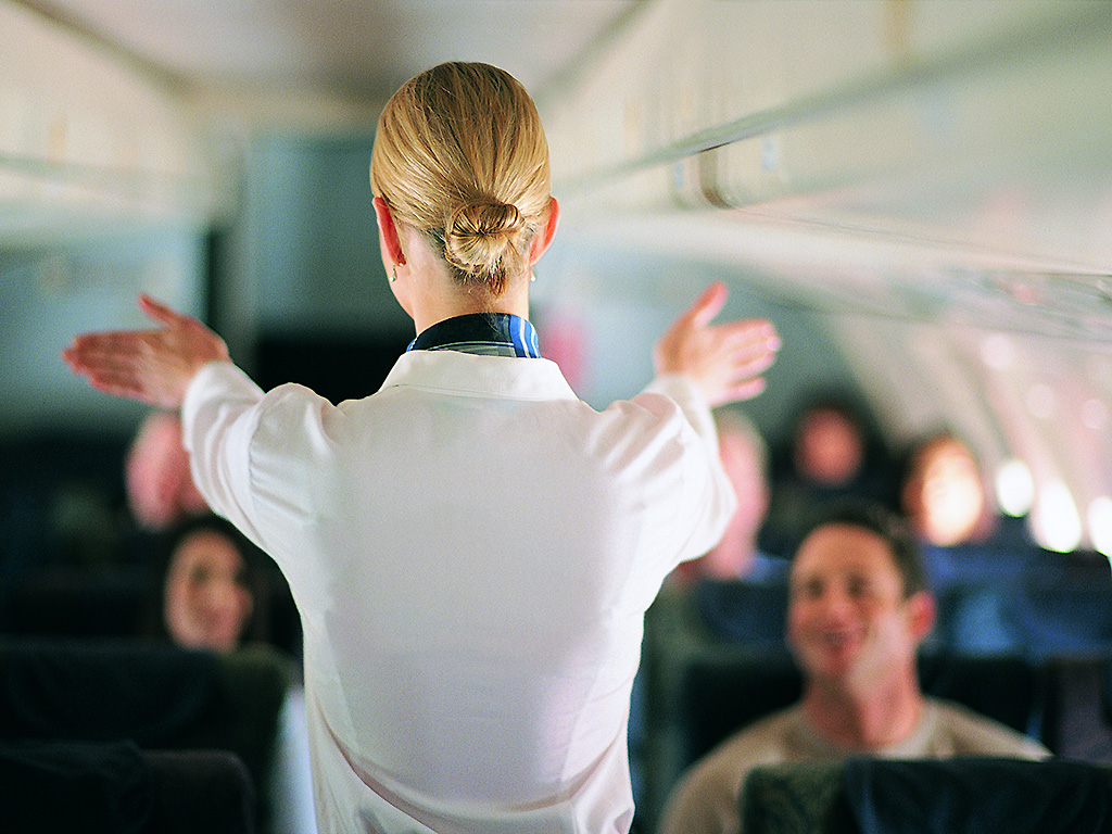 A flight attendant runs through safety procedure on an aircraft.
