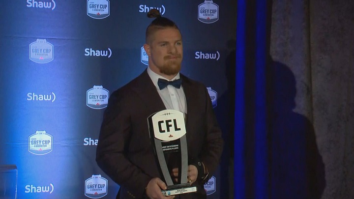 Winnipeg Blue Bombers linebacker Adam Bighill shows off his Most Outstanding Defensive Player Award.
