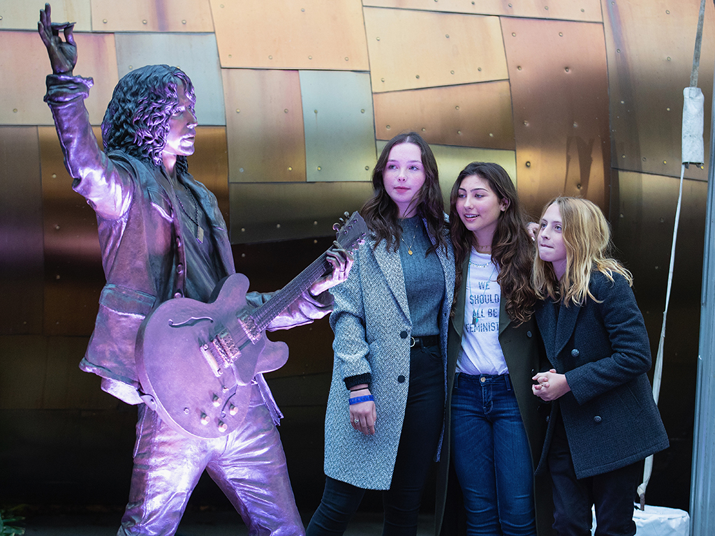 (L-R) Lily Cornell, Toni Cornell and Christopher Cornell unveil a life-size statue of their father, Chris Cornell during the public unveiling ceremony at MoPop on Oct. 7, 2018 in Seattle, Wash.