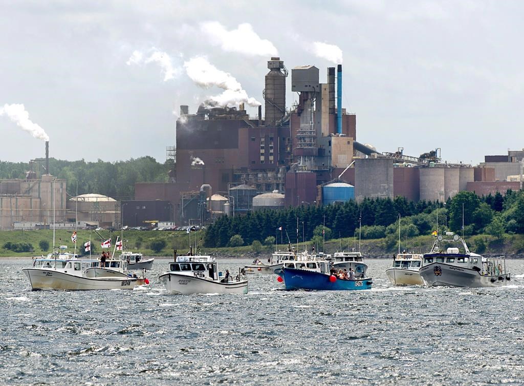 Fishing boats pass the Northern Pulp mill as concerned residents, fishermen and Indigenous groups protest the mill's plan to dump millions of litres of effluent daily into the Northumberland Strait in Pictou, N.S., on Friday, July 6, 2018. A group of fishermen from several ports along the Northumberland Strait say they will block a survey boat hired by Northern Pulp from entering the strait to do work on a proposed new route for an effluent pipe. THE CANADIAN PRESS/Andrew Vaughan.