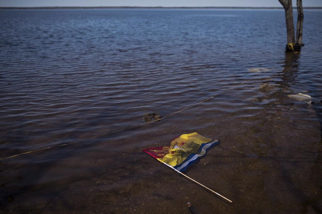 A New Brunswick flag floats in floodwater from the Saint John River in Waterborough, N.B., on May 13, 2018. (THE CANADIAN PRESS/Darren Calabrese)