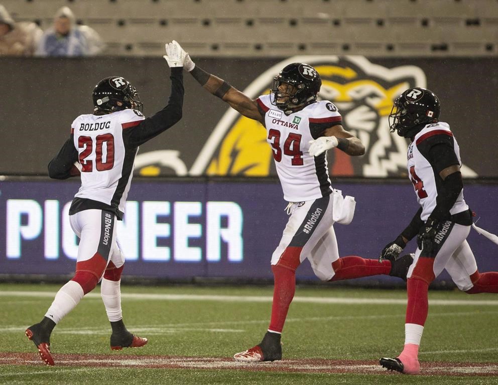 Ottawa Redblacks Kyries Hebert (34) celebrates with teammate Jean-Philippe Bolduc (20) after making an interception during second half CFL Football game action against the Hamilton Tiger-Cats in Hamilton, Ont. on Saturday, October 27, 2018. The Ottawa Redblacks will be without a number of its starters Friday night as they wrap up the regular season against the Toronto Argonauts, but the mindset remains the same.