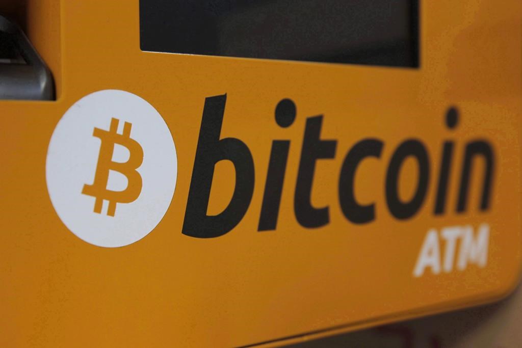 A Bitcoin logo is shown is displayed on an ATM in Hong Kong on December 21, 2017. 
