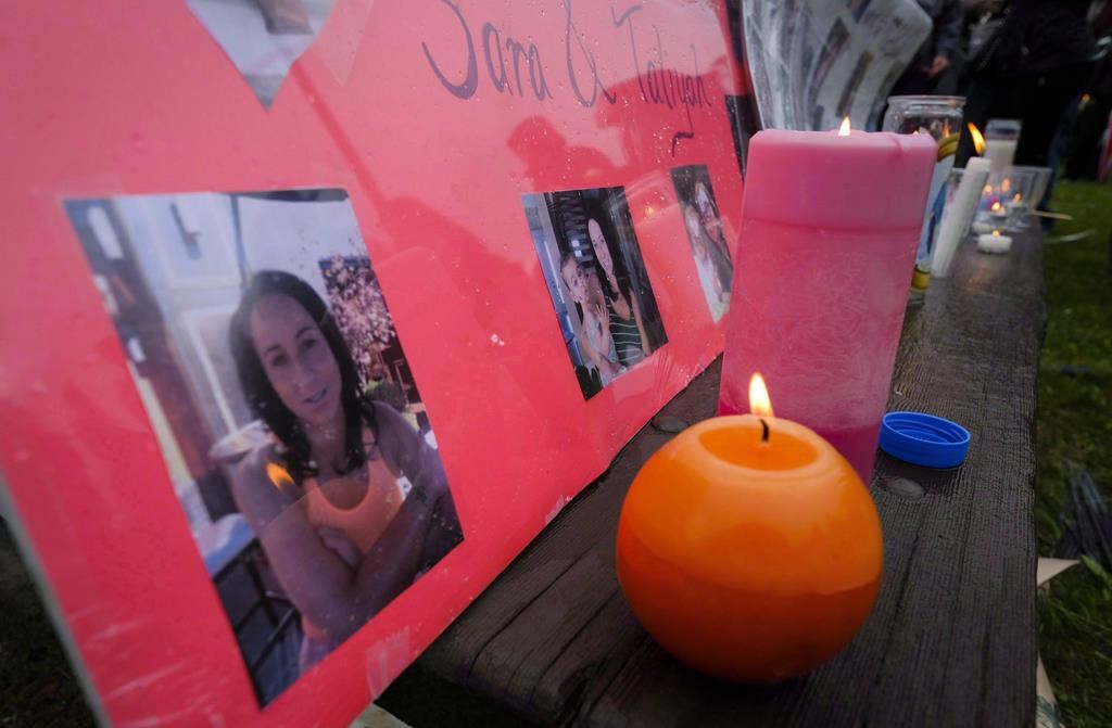 Lit candles and photographs are seen on display at a vigil for Calgary homicide victims Sara Baillie and her five-year-old daughter Taliyah Marsman, in Calgary, on July 17, 2016.