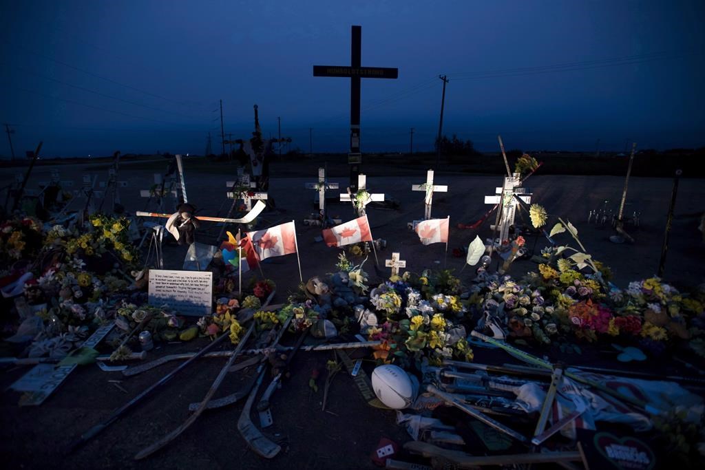 A memorial made of hockey sticks, crosses and Canadian flags is seen at the crash site of the Humboldt Broncos hockey team near Tisdale, Sask., Friday, August, 24, 2018.