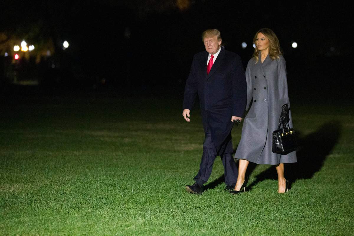 President Donald Trump walks with first lady Melania Trump, after stepping off Marine One, on the South Lawn of the White House, Sunday, Nov. 11, 2018, in Washington. Trump is returning from a trip to Paris.