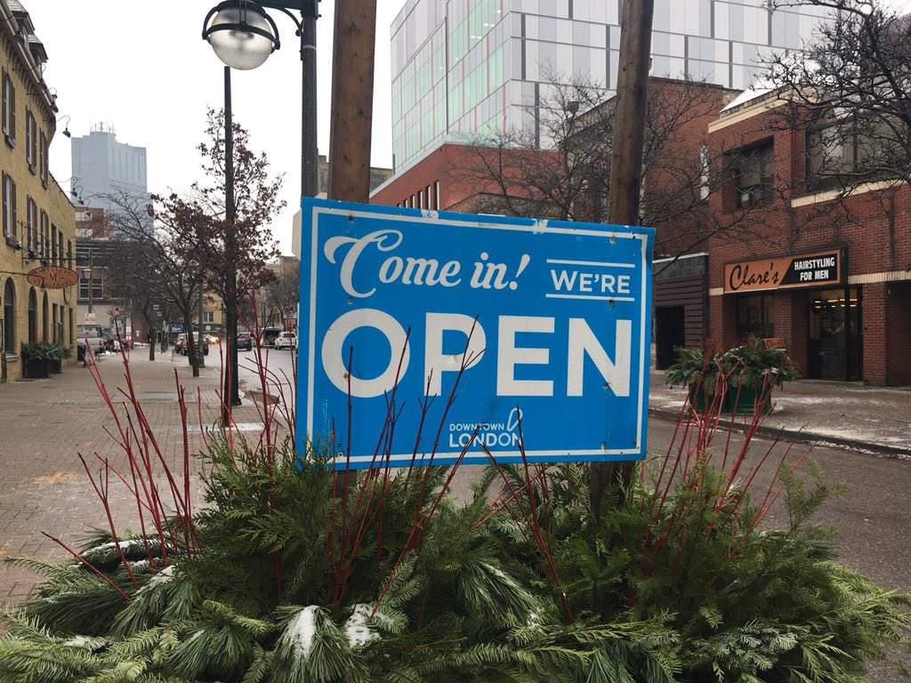 A downtown London sign alerts residents that businesses remain open despite road construction. 